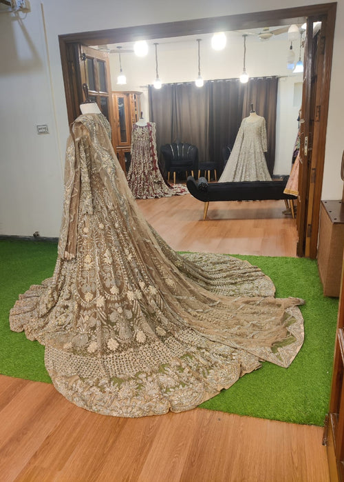 Elegant embroidered saree on a green carpet with a mirror reflection.