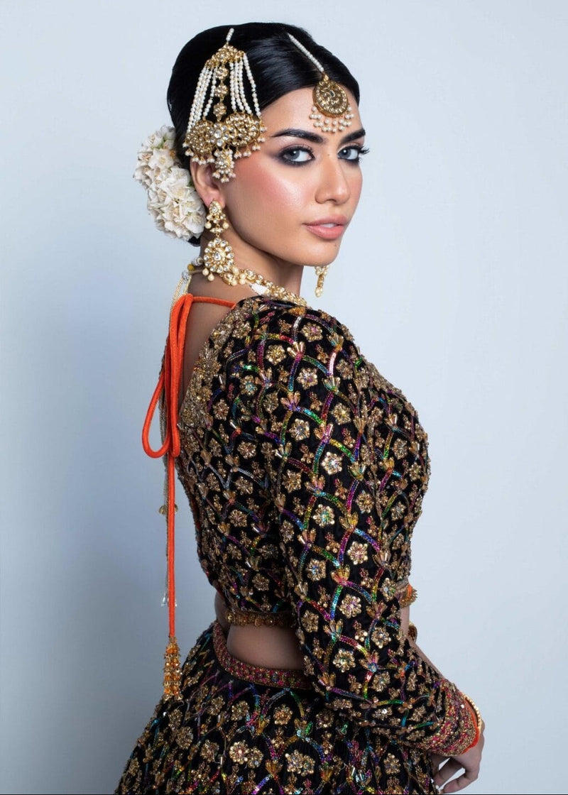 Woman in traditional attire with intricate jewelry against a light gray background NAUSHAYZ by Fahad Hussayn